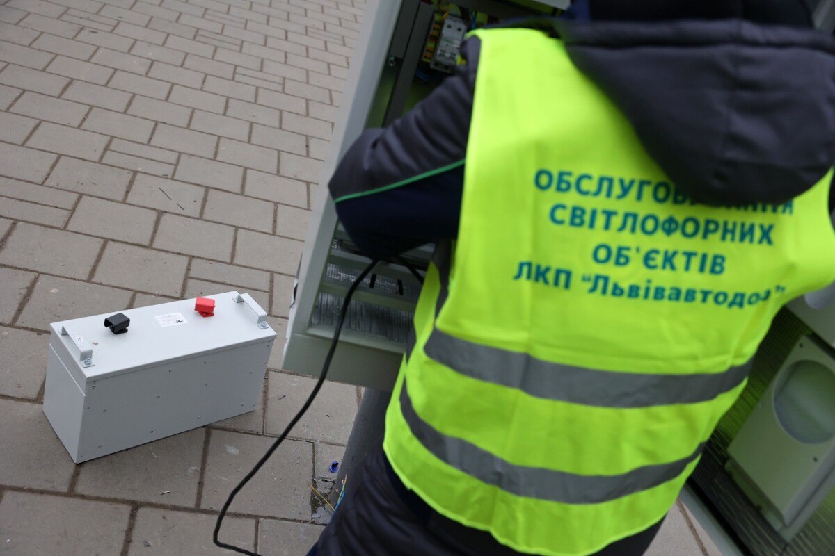 Працівник проводить заміну акумулятора забезпечення роботи світлофора