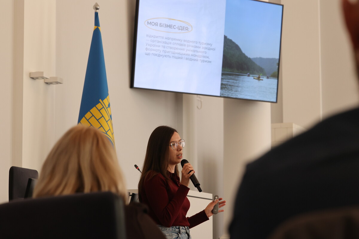 Ірина Малець, дружина військовослужбовця розповідає про клуб мандрівників «Бродячі пси». На екрані сплав на байдарках.