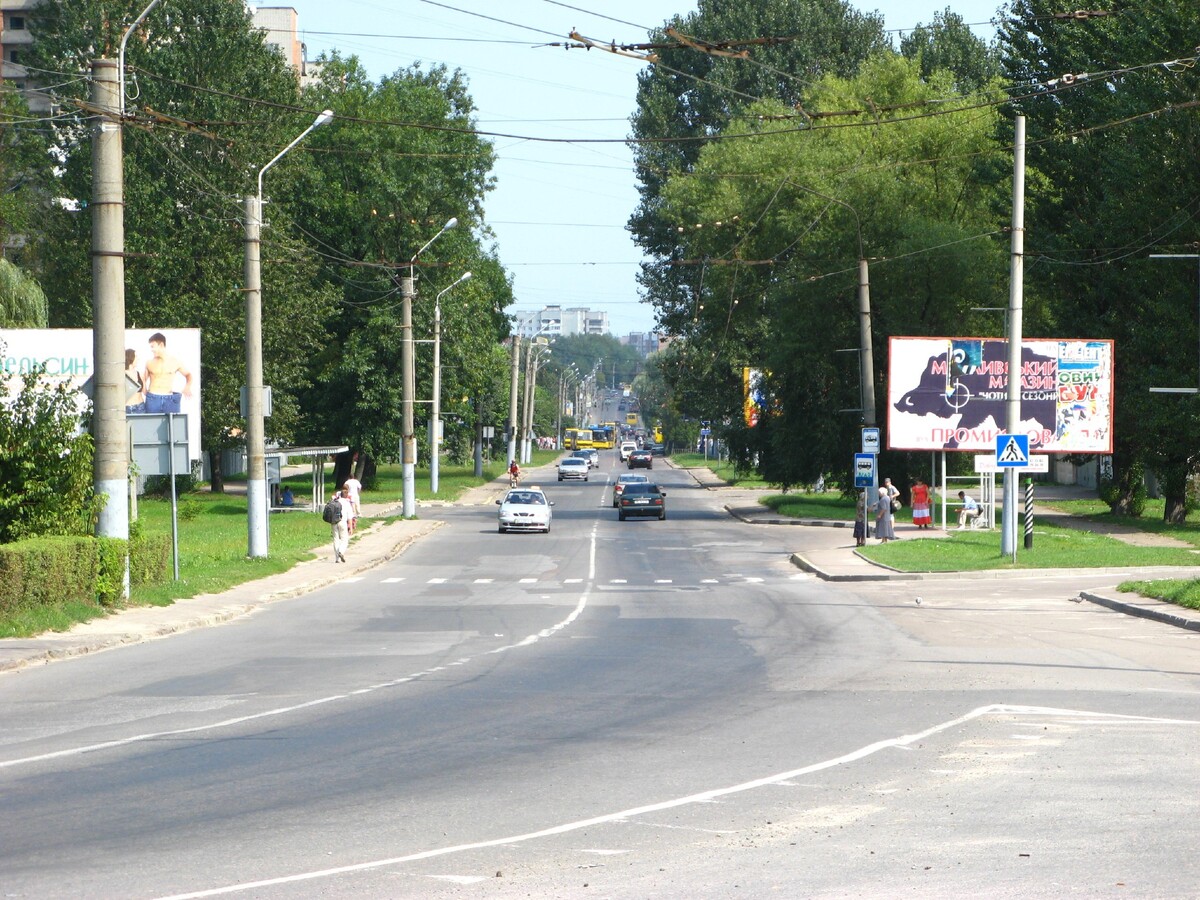 Вулиця Мазепи. Уздовж ростуть дерева, по дорозі їдуть машини. На узбіччі видно людей та зупинки транспорту.