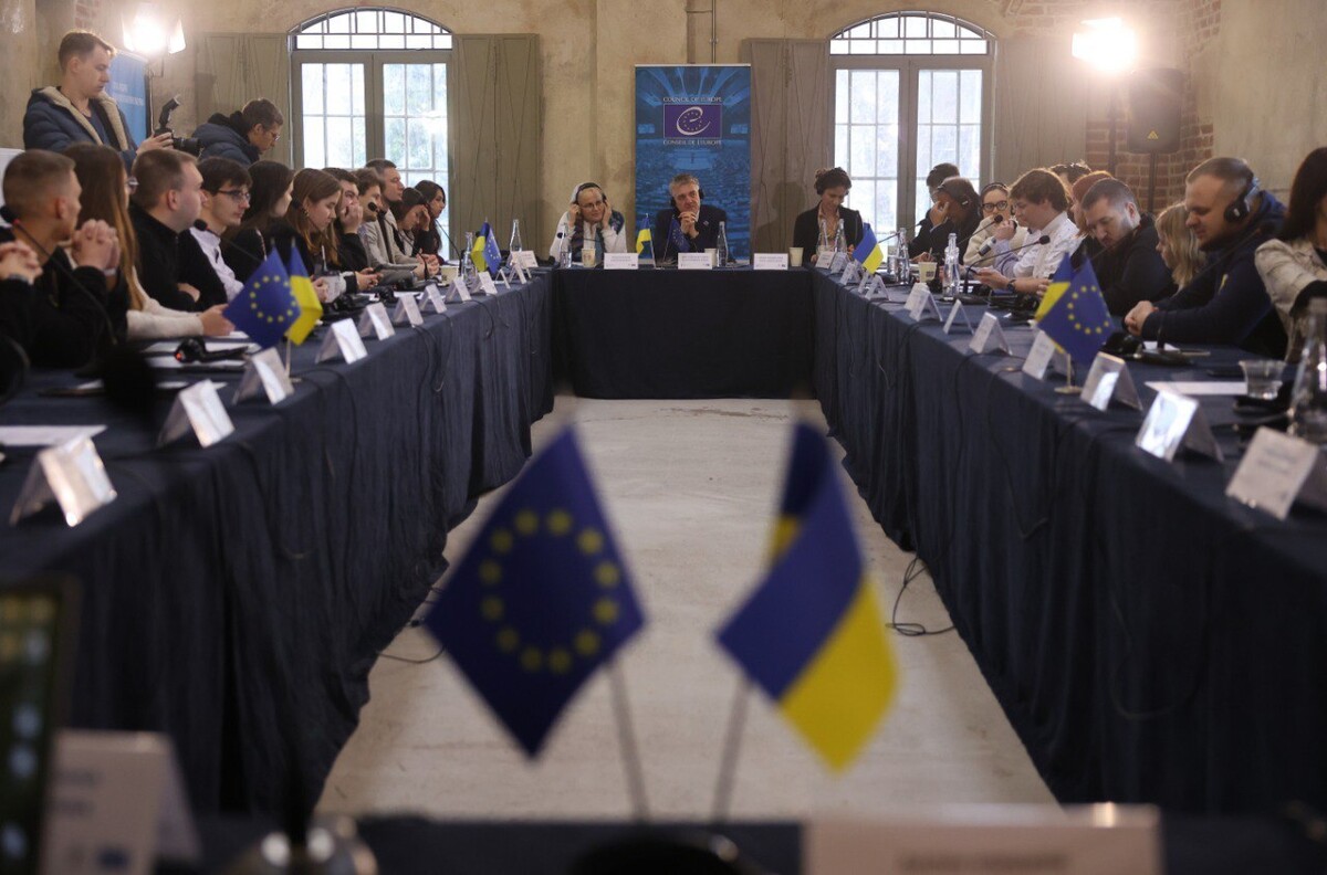 Представники з українських та європейських організацій, які займаються молодіжною політикою сидять за столом.