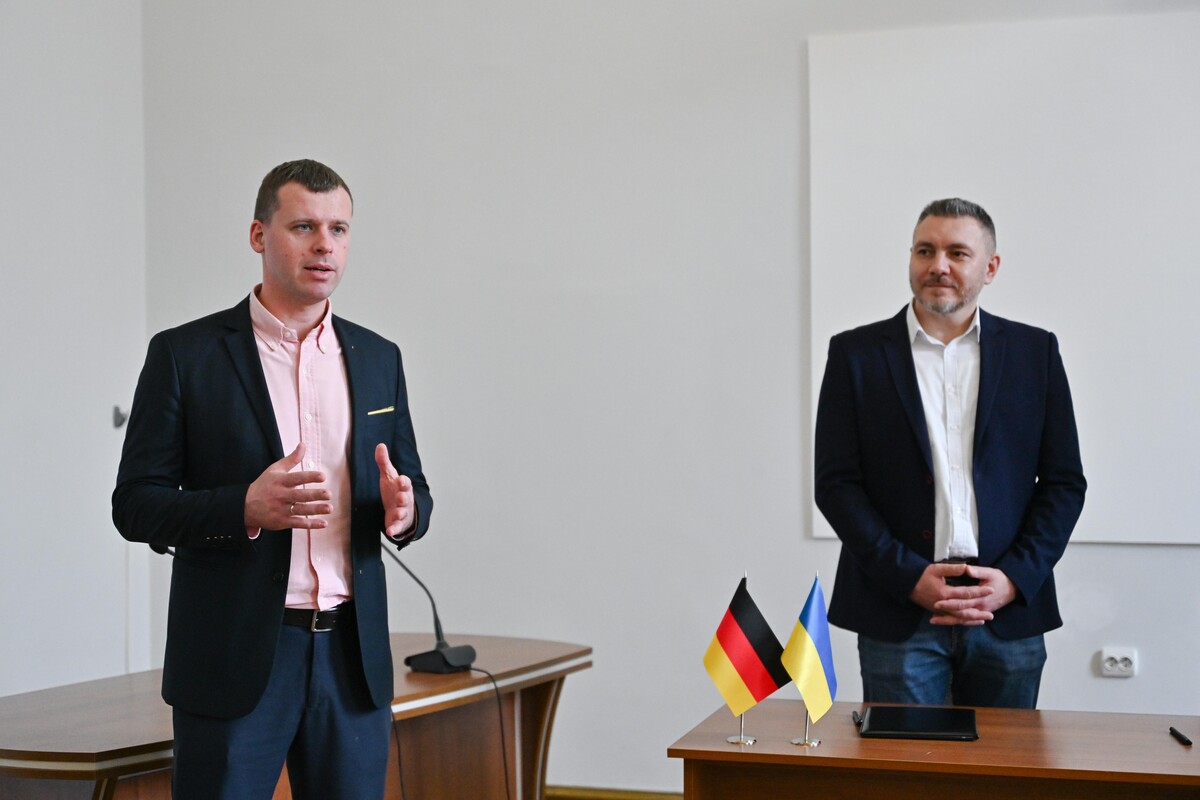 Олег Забарило, директор департаменту міської мобільності та вуличної інфраструктури розповідає про суть меморандуму. Поруч нього стоїть Микола Гандера, радник з технічних питань будівництва GIZ
