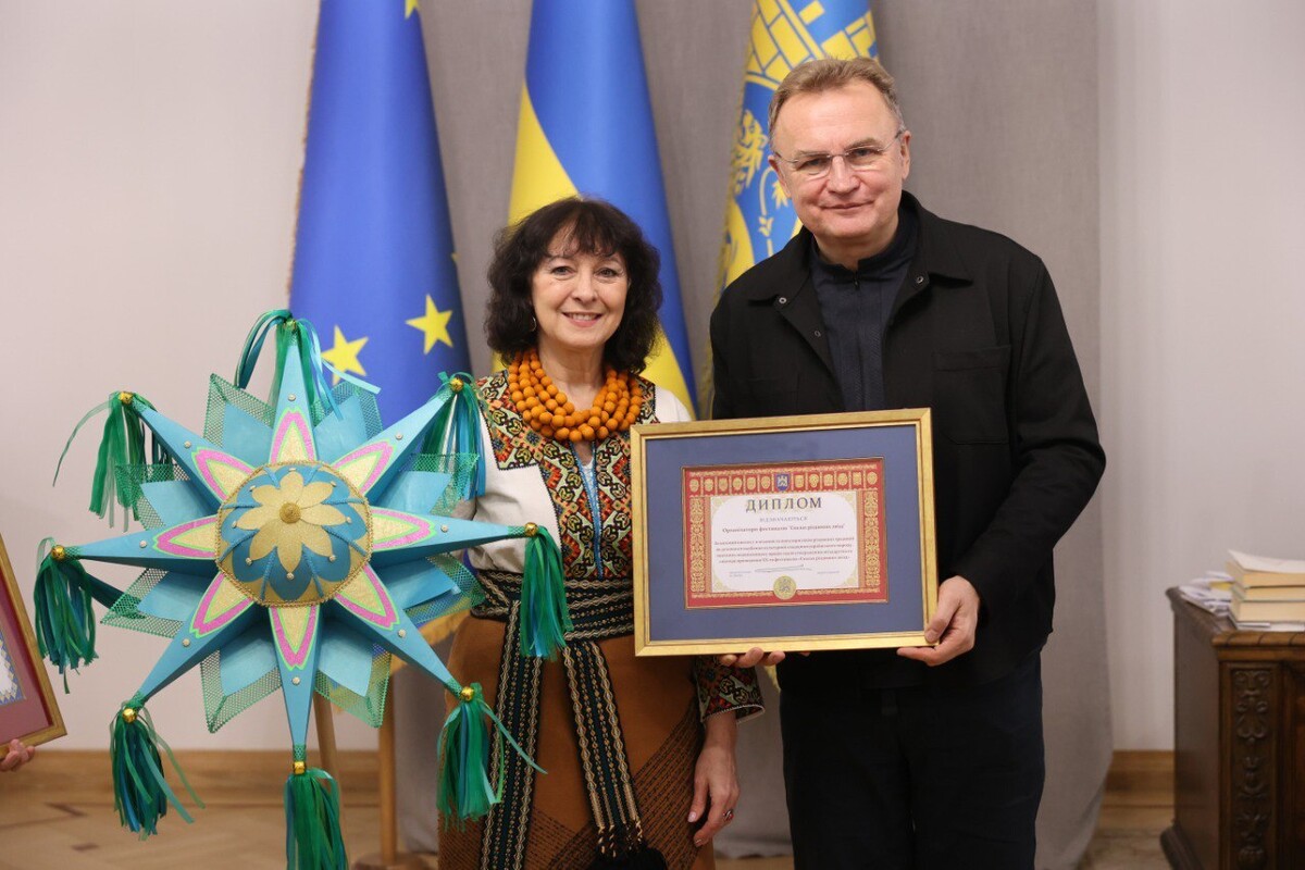 Мер Львова Андрій Садовий вручає диплом Надії Дзвоник, яка тримає у руці яскраву велику звізду зелених відтінків.