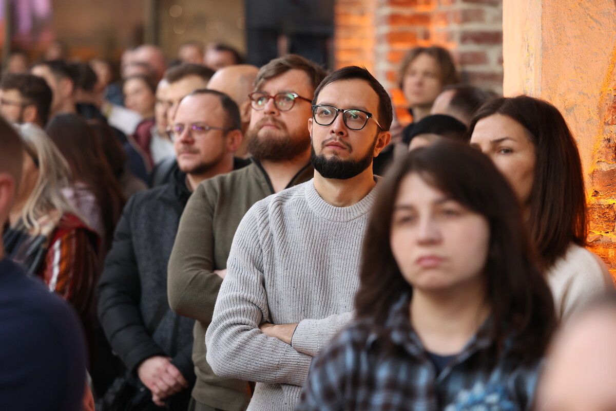 Учасники зустрічі, серед яких ветеран Андрій Каспшишак, слухають виступ мера під час презентації звіту за 2025 рік
