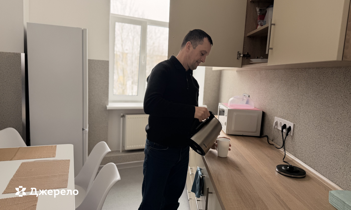 Григорій на кухні прихистку заварює чай: із чайника лиє воду у стаканчик