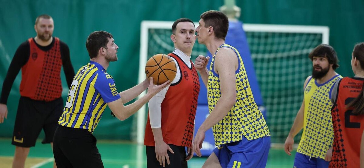 Учасники турніру грають в баскетбол.