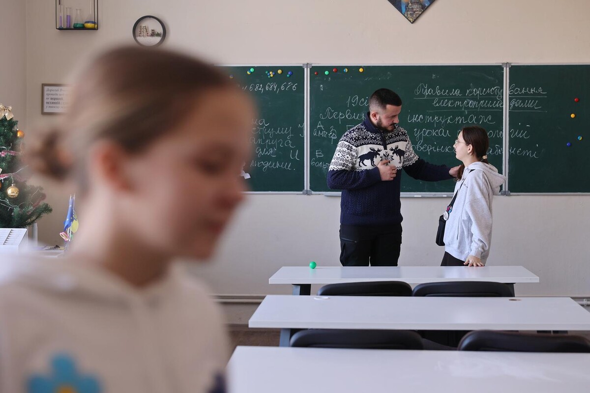 Ігор Дусан спілкується з ученицею у шкільному класі.
