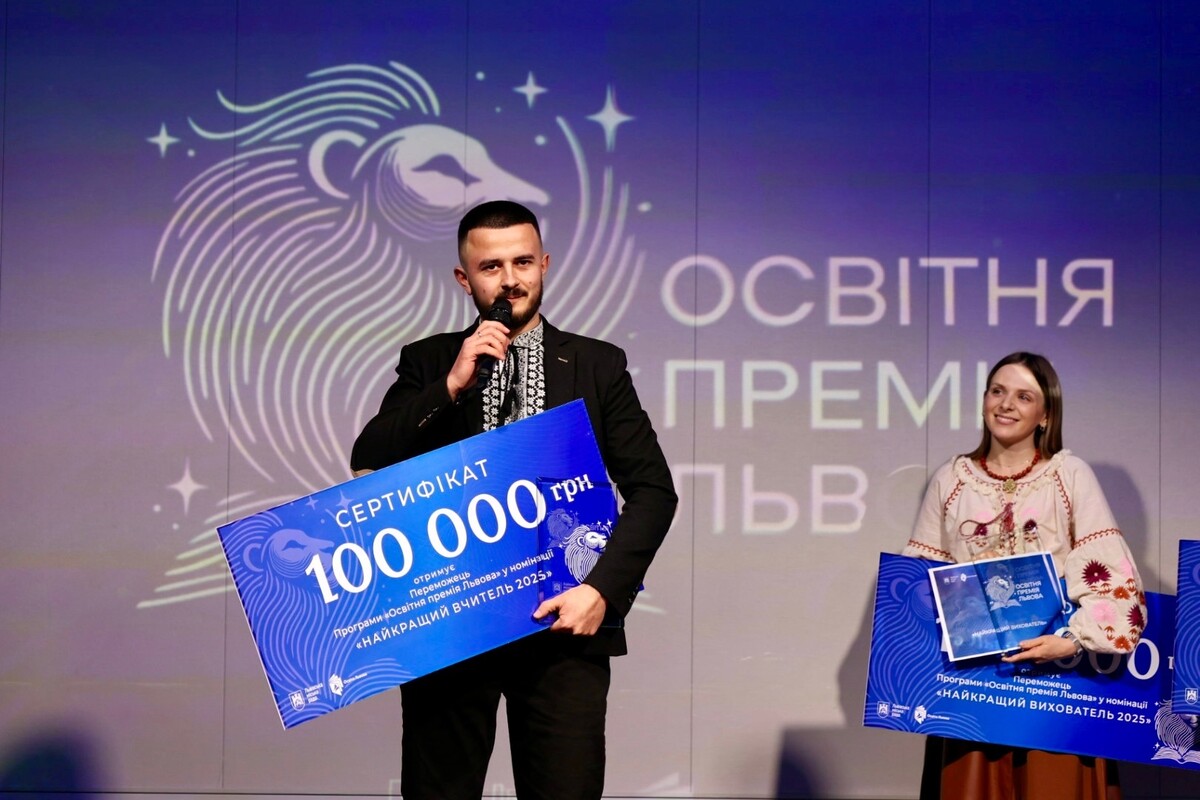 Ігор Дусан на сцені під час нагородження &ldquo;Освітньої премії Львова&rdquo;. Вчитель говорить у мікрофон та тримає сертифікат на суму 100 тисяч гривень