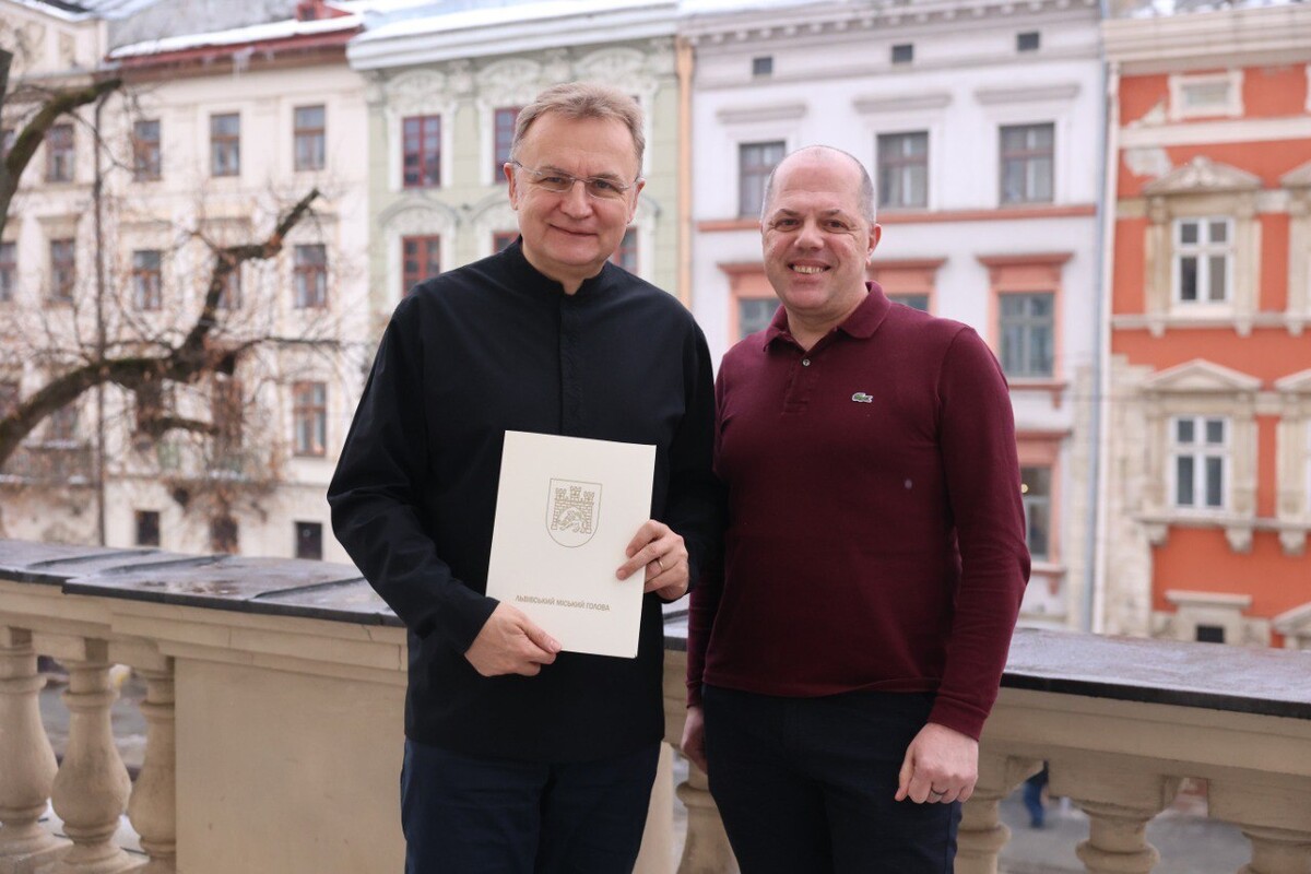 мер Львова Андрій Садовий тримає у руках вітальний лист для довгожительки. Поруч - Іван Фасольник, представник міського управління соціального захисту.