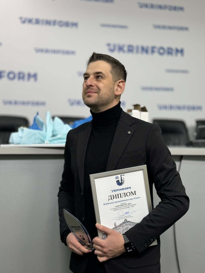 Тарас Демко тримає у руках диплом та скляну відзнаку.