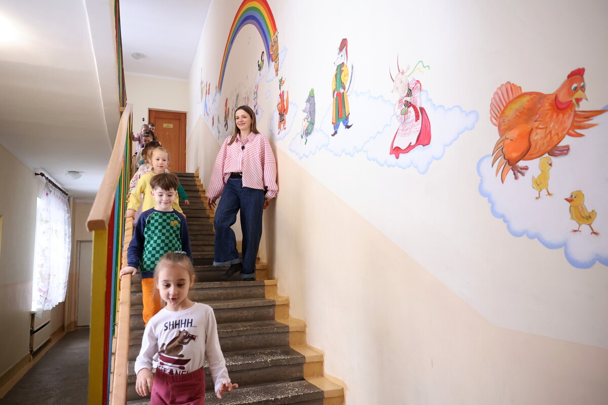 Устина стоїть на сходах, по яким спускаються діти.