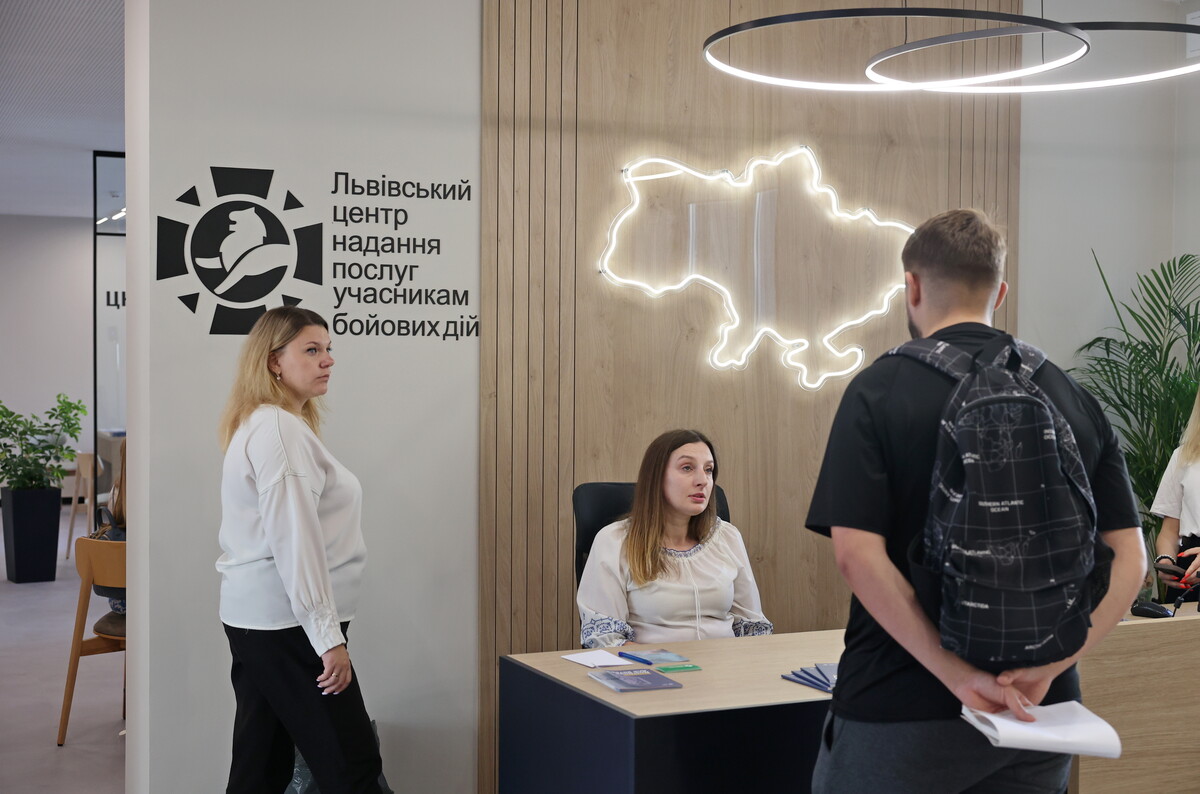 У центрі надання послуг учасникам бойових дій дві адміністраторки консультують відвідувача
