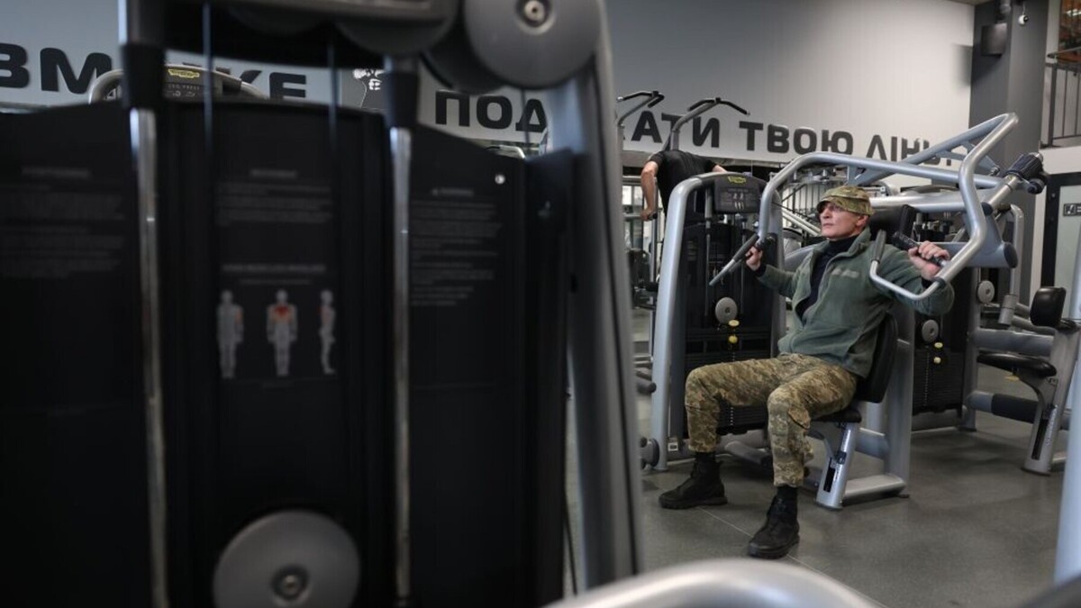 Чоловік у військовій формі на одному із тренажерів виконує вправи