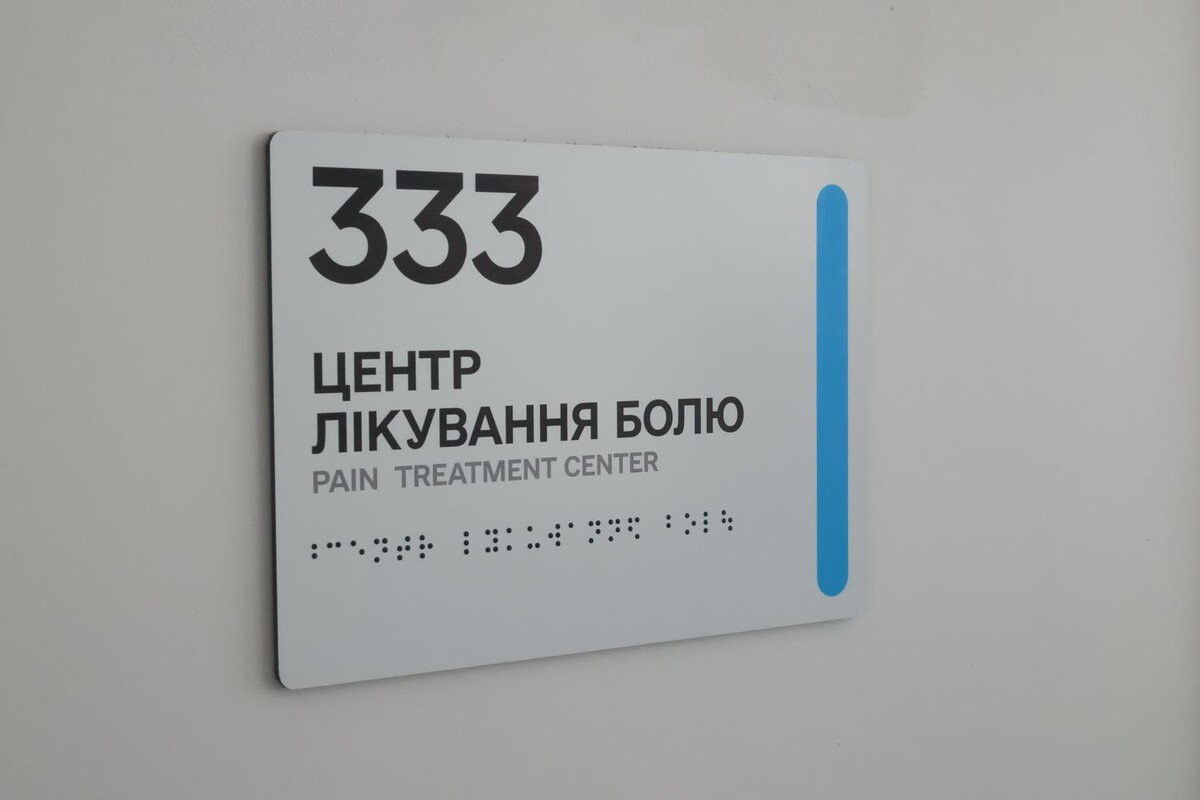 Вивіска на дверях, на якій вказано номер &laquo;333&raquo; та напис &laquo;Центр лікування болю&raquo;. Також напис дублюється англійською і шрифтом Брайля