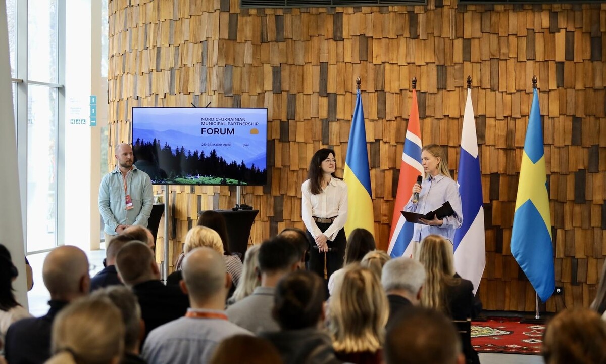 Ведучі на сцені форуму під час 2-го дня події. Позаду них зображено прапори країн-партнерів: Швеції, Норвегії, Фінляндії та України. Перед ведучими сидять учасники події