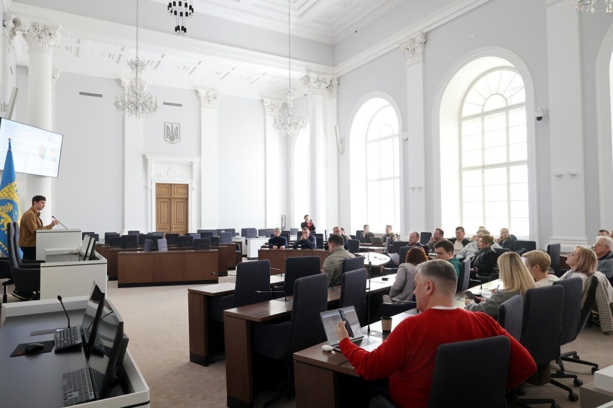 Кілька десятків підприємців за столами у Великій сесійній залі Львівської міськради беруть участь в обговоренні стандарту апаратів. Біля трибуни Роман Крушельницький