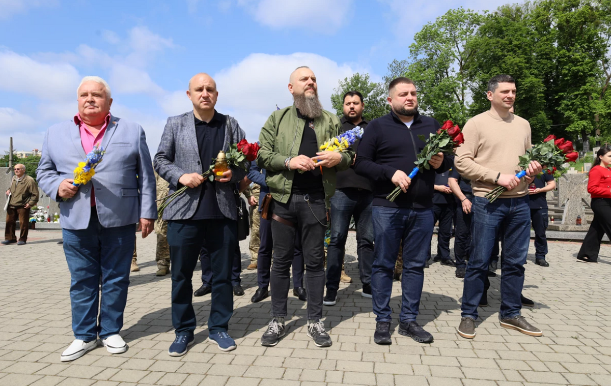 Андрій Жолоб, заступник міського голови – омбудсмен з питань ветеранів та людей з інвалідністю, поруч з іншими учасниками пам’ятного заходу. Усі тримають в руках квіти. Фото: ЛОДА