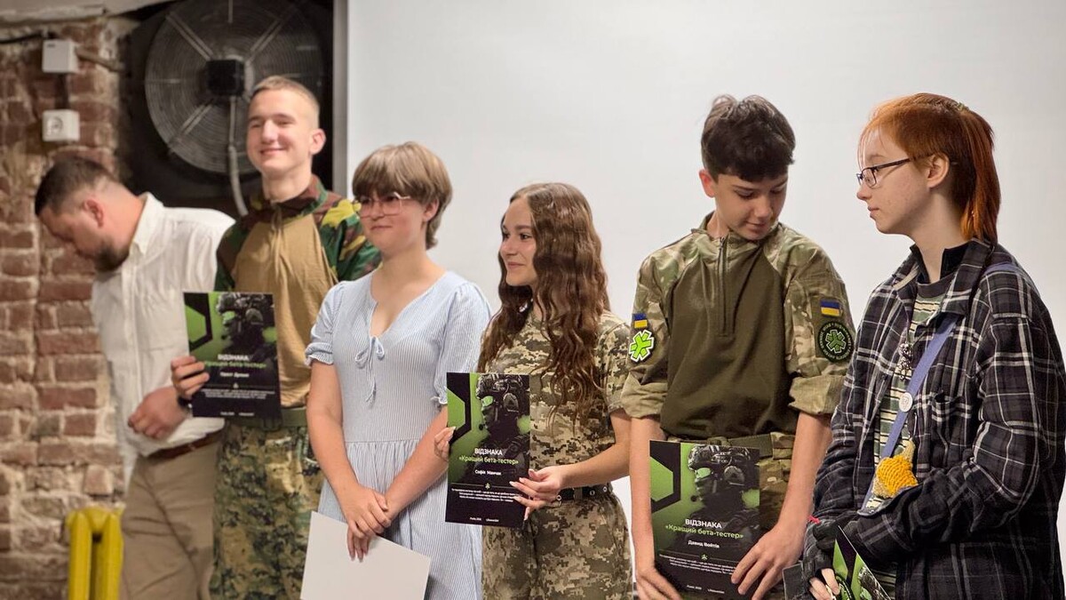 Нагородження учнів подяками та сертифікатами за досягнення у застосунку LifesaverSIM. Молодь стоїть у цивільному одязі та військовій формі. В руках у них сертифікати