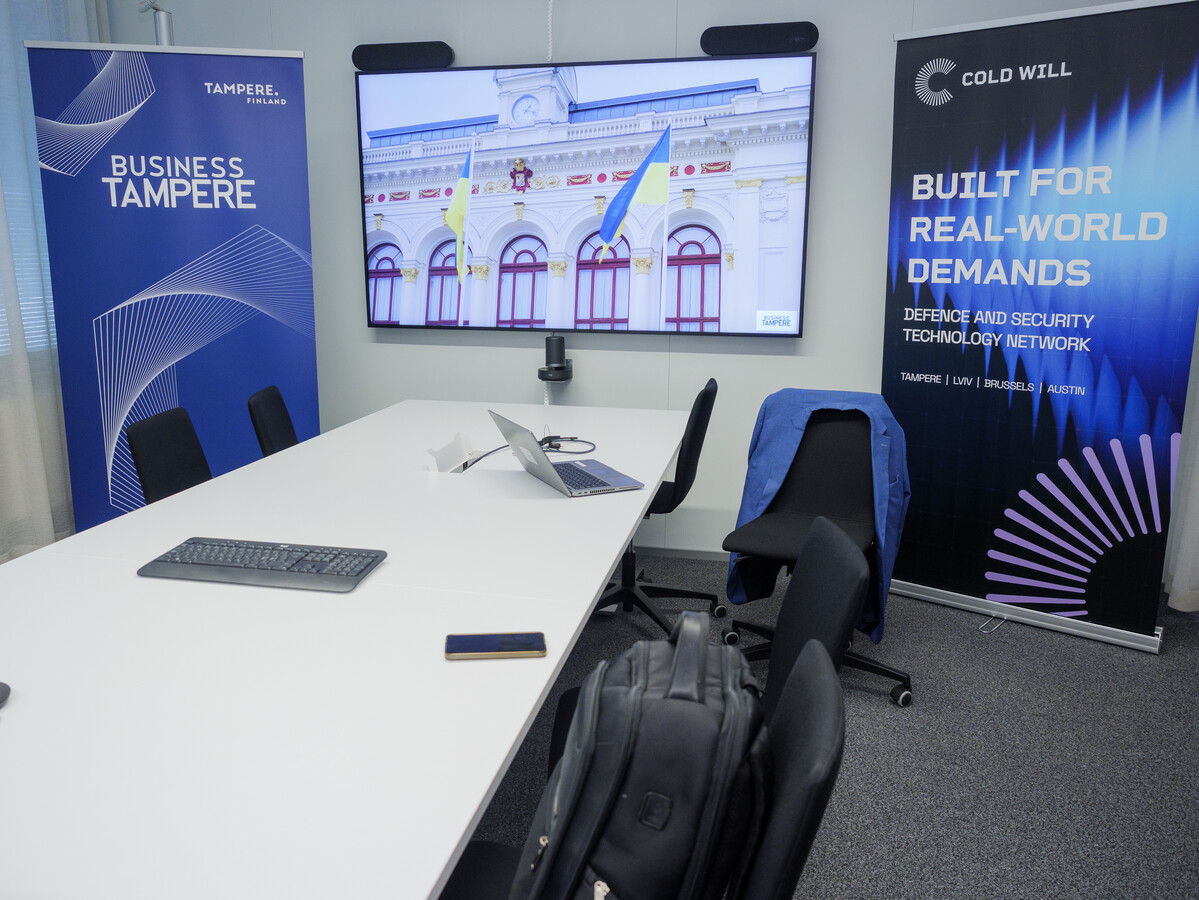 Офіс Business Tampere. На фото видно два банери по обидва боки від великого телевізора, на якому є зображення українських прапорів біля будівлі