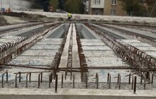 Фото 5: Будівництво шляхопроводу на Рясне: між мостовими балками вже встановлюють плити