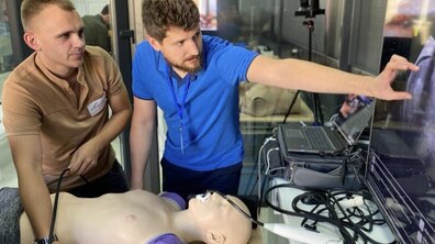 двоє лікарів з допомогою манекену вчаться надавати допомогу, зокрема роблять УЗД