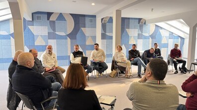 Кілька десятків людей сидять в колі під час зустрічі заступника міського голови Любомира Зубача, посадовців міськради та депутатів з представниками підприємців, що працюють у МАФах на вул. Чернівецькій. Обговорення проходить у синій залі Львівської міської ради