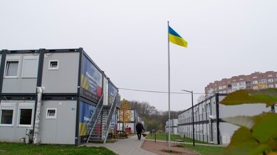 Людина йде на фоні модульного містечка