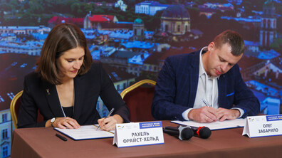 Керівниця проєкту Інтегроване міське відновлення в Україні Рахель Фрайст-Хельд та директор департаменту міської мобільності та вуличної інфраструктури Львівської міської ради Олег Забарило підписують грантову угоду