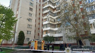 Багатоповерховий житловий будинок на вул. Юрія Липи, 39. У дворі стоїть червона пожежна машина з розгорнутим шлангом. Поруч працюють рятувальники. Територія оточена червоно-білою загороджувальною стрічкою. Фото Національної поліції України.