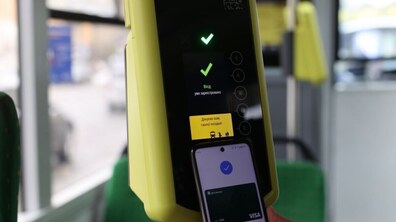 Смартфон, прикладений до валідатора у салоні громадського транспорту