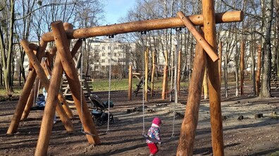 дитина біля сучасної дерев’яної гойдалки на дитячому майданчику в парку Виговського