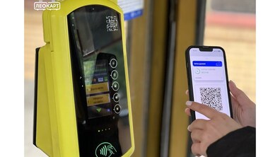 Пасажирка підносить смартфон із відкритим у застосунку LeoCard QR-кодом до жовтого валідатора у салоні транспорту