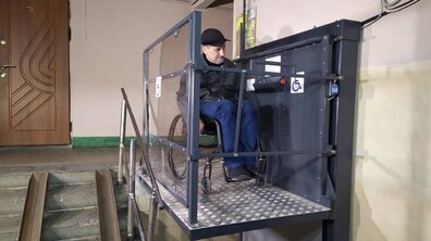чоловік на кріслі колісному користується підйомником.