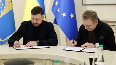 Мер Львова Андрій Садовий та мер Маріуполя Вадим Бойченко в Білій залі Львівської міської ради за столом підписують Меморандум про співпрацю. Позаду них прапори ЄС, України та Львова