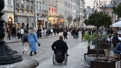 чоловік на кріслі колісному пересувається площею Ринок