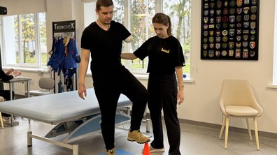 Пацієнт Михайло займається в реабілітаційному залі з фізичною терапевткою: він виконує вправи для кращої координації руху