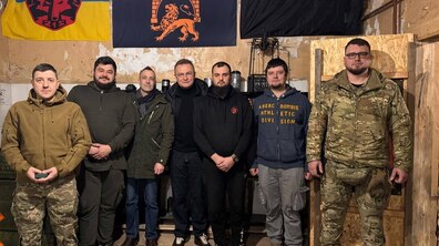Міський голова Львова разом з захисниками. Позаду на стіні висять прапор Львова, червоно-чорний стяг та прапор 215 батальйону тероборони