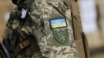 Рука військовослужбовця з нарукавним знаком Державний Прапор України та нарукавним знаком військової частини
