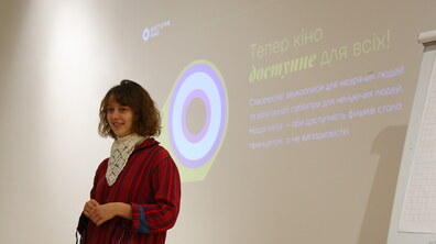Спікерка проводить лекцію. На слайді напис — “Тепер кіно доступне для всіх”