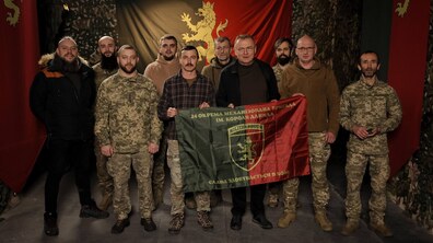 Міський голова Львова Андрій Садовий разом з військовими тримають прапор