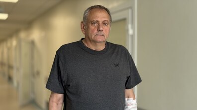 Пацієнт, 68-річний львів'янин пан Андрій, стоїть у холі лікарні