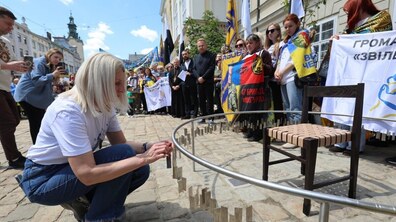 Мати зниклого безвісти захисника чіпляє жетон з іменем сина на 