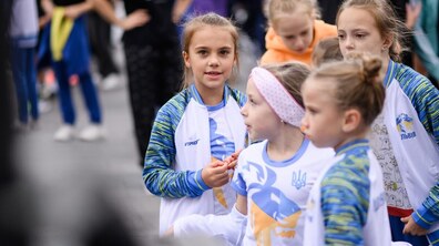 (Діти у спортивній формі. Позаду видно інших людей