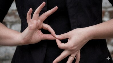 Руки людини, яка використовує жестову мову, з'єднавши великі та вказівні пальці обох рук у формі ланок ланцюга.