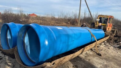 Дві великі поліетиленові труби синього кольору, які прокладають у с. Бартатові