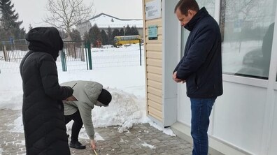 Ірина Маруняк, заступниця міського голови Львова з питань доступності, проводить заміри біля амбулаторії у с. Великі Грибовичі. З правого боку від неї стоїть чоловік, а з лівого боку – жінка із записником і ручкою у руках.