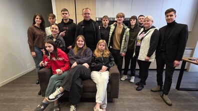Мер Львова Андрій Садовий разом з працівниками та мешканцями Малого групового будинку Спільнота «Рідні». Частина дітей сидять на дивані. Інші обіймаються та усміхаються