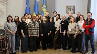 Міський голова Андрій Садовий та більше десятка учасників резиденції у кабінеті мера на фоні прапорів Львова, України та ЄС. На стіні - герб міста.