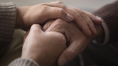 Руки однієї людини тримають руки іншої людини – як символ підтримки