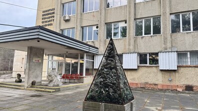 Будівля Львівської кераміко-скульптурної фабрики. На передньому плані трикутна конструкція, заповнена битим склом. Біля входу на фабрику – скульптура погруддя Тараса Шевченка