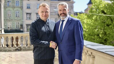 Карл Негаммер та міський голова Львова Андрій Садовий на балконі ратуші тиснуть один одному руки.